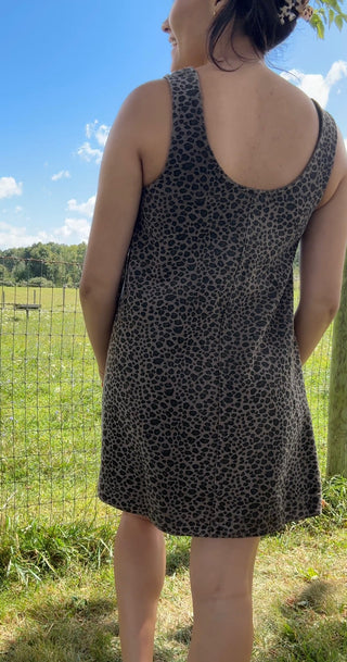 Back view of sleeveless charcoal gray swing dress with black leopard spots and a flattering scoop neckline.