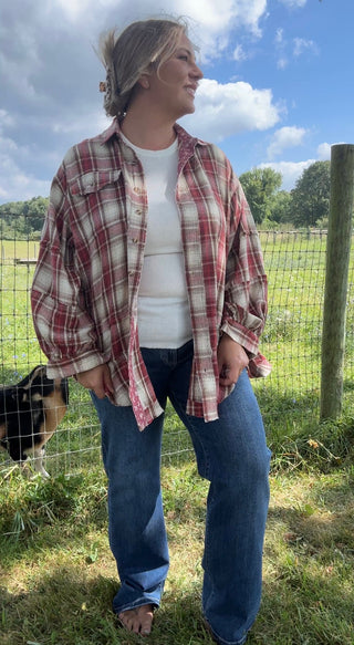 Front view of a relaxed red plaid flannel shirt layered over a white tank top, paired with classic blue jeans for a casual fall look.