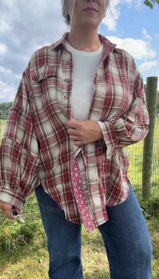 Cozy red plaid flannel shirt layered over a white ribbed tank, styled with classic blue jeans for a laid-back fall look.