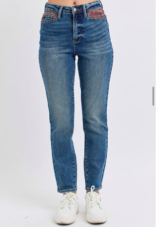 High-rise medium wash skinny jeans with subtle fading and red southwestern print accents on the front pockets.