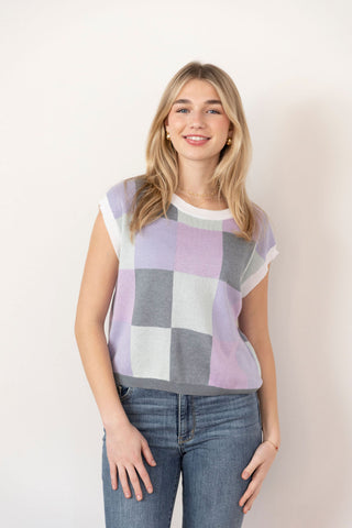 Chic pastel plaid sweater vest with soft lavender, white, and gray hues, a classic knit design, and a relaxed fit for effortless layering.