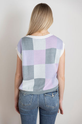 Trendy sleeveless knit vest with a pastel checkered pattern in lavender, gray, and white, perfect for casual or preppy styling.