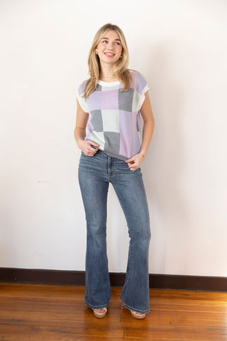 Trendy sleeveless knit vest with a pastel checkered pattern in lavender, gray, and white, perfect for casual or preppy styling.