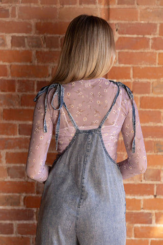 Trendy denim overalls with relaxed fit, styled over a delicate floral mesh top. Perfect for casual and layered looks.