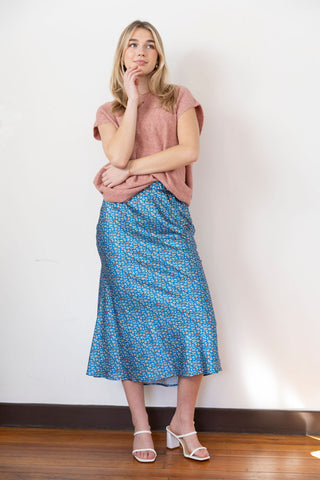 Floral blue midi skirt with a silky texture, perfect for an elegant yet casual look, styled with a cozy knit top.