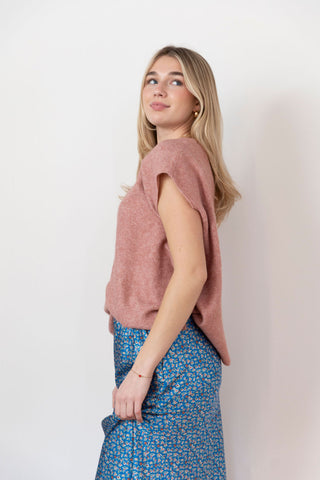 Women's blush pink knit sweater with cap sleeves and a relaxed fit. Soft, textured fabric with a slightly asymmetrical hem.