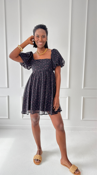 Black floral mini dress with puff sleeves, square neckline, and smocked back, featuring a delicate red and white floral print.