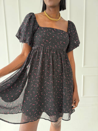 Black floral mini dress with puff sleeves, square neckline, and smocked back, featuring a delicate red and white floral print