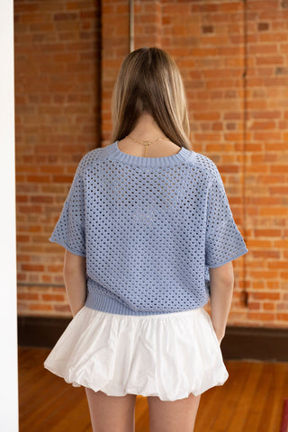 Soft blue crochet-style cardigan with button front and airy short sleeves, perfect for effortless layering.